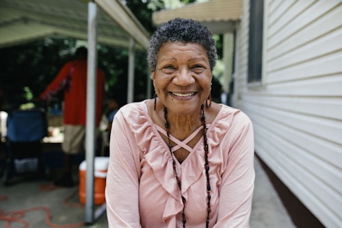 older woman outdoors smiling while sitting