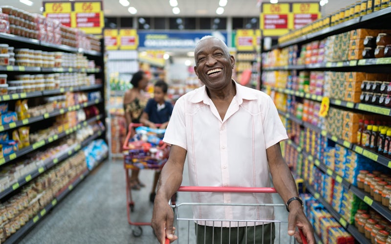 older man walking down aisle at grocery store