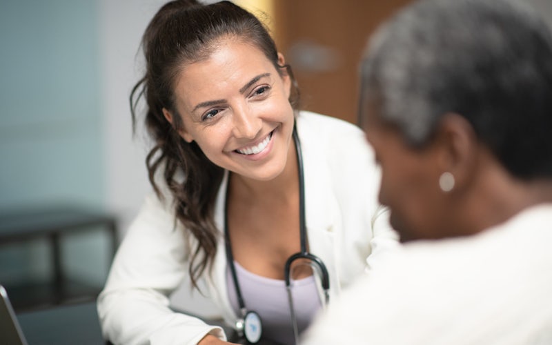 Doctor smiling at older patient in office