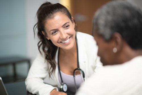 Doctor smiling at older patient in office