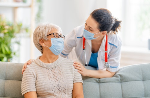 doctor in mask with patient on couch