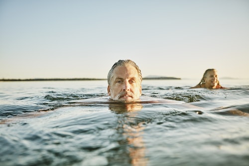 older man swimming outside in the ocean