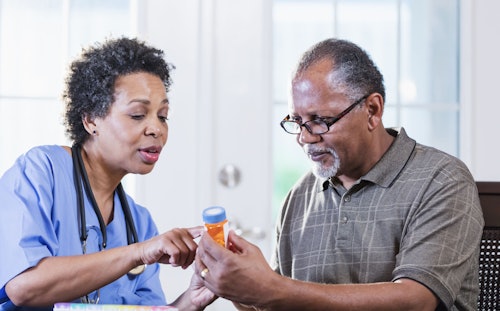 older man reviewing medications with doctor