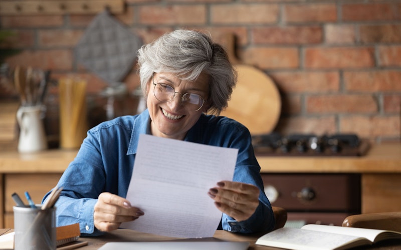 older woman at table reviewing paperwork