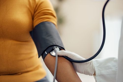 A close up of a person getting their blood pressure taken by doctor.
