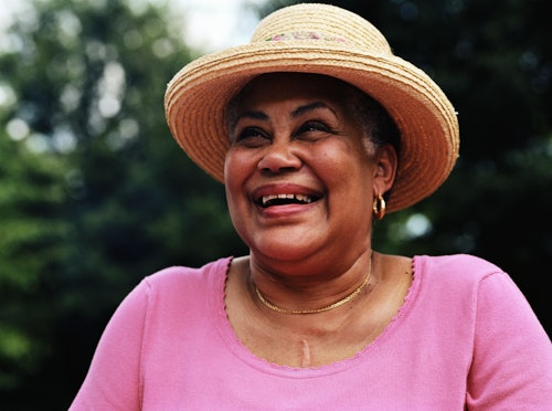 Woman smiling in pink shirt and sunhat