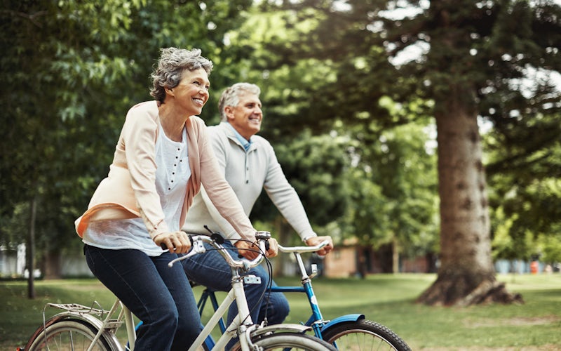 older couple riding bikes in woods