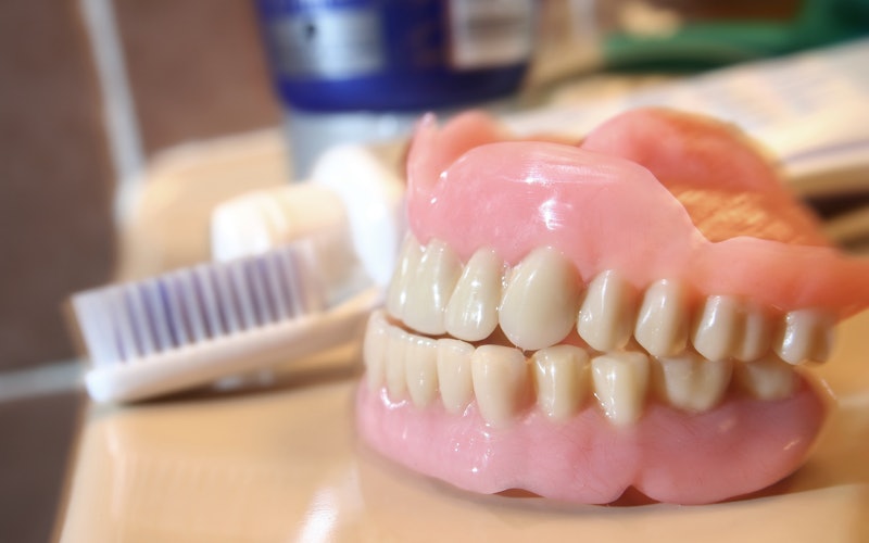 Dentures and toothbrush on a table