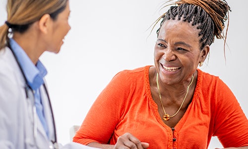 A patient smiles while looking at a physician.