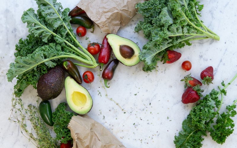 brown paper bags with vegetables avocados and greens