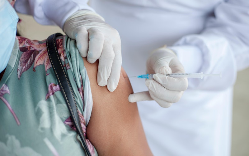 Doctor vaccinating patient in the upper arm