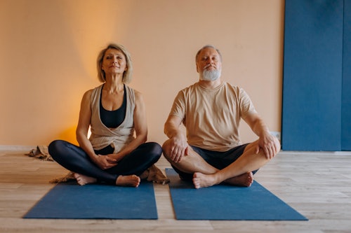 Man and Woman Sitting on Blue Yoga Mat