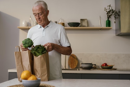 Man in White Polo Shirt Getting the Vegetable From Paper Bag