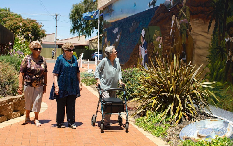 older women outside walking with walker