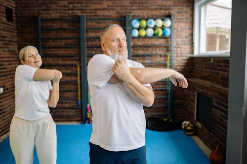 An Elderly Couple Doing Arms Stretching Exercise