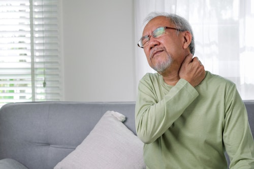 Older man holding his neck in discomfort