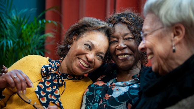 three ladies smiling together outside