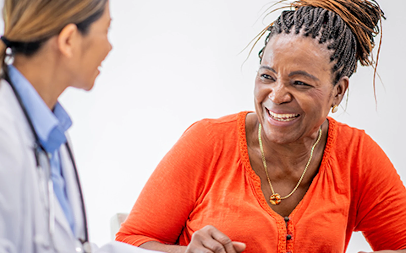 A patient smiles while looking at a physician.