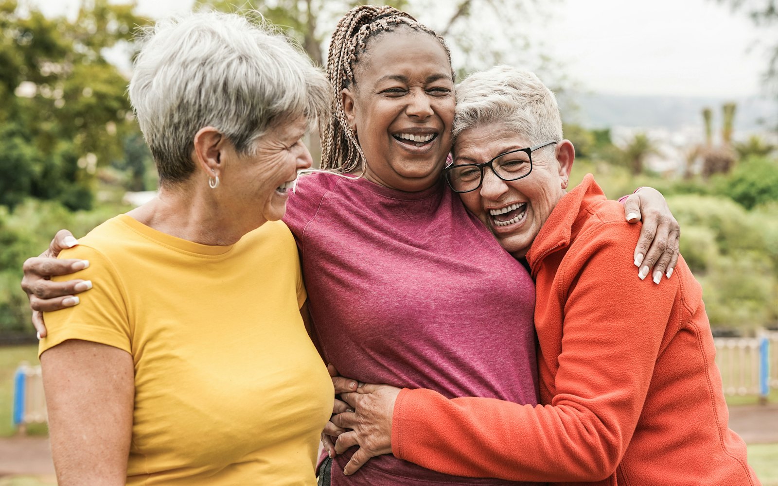 Older women laughing and hugging, best friends