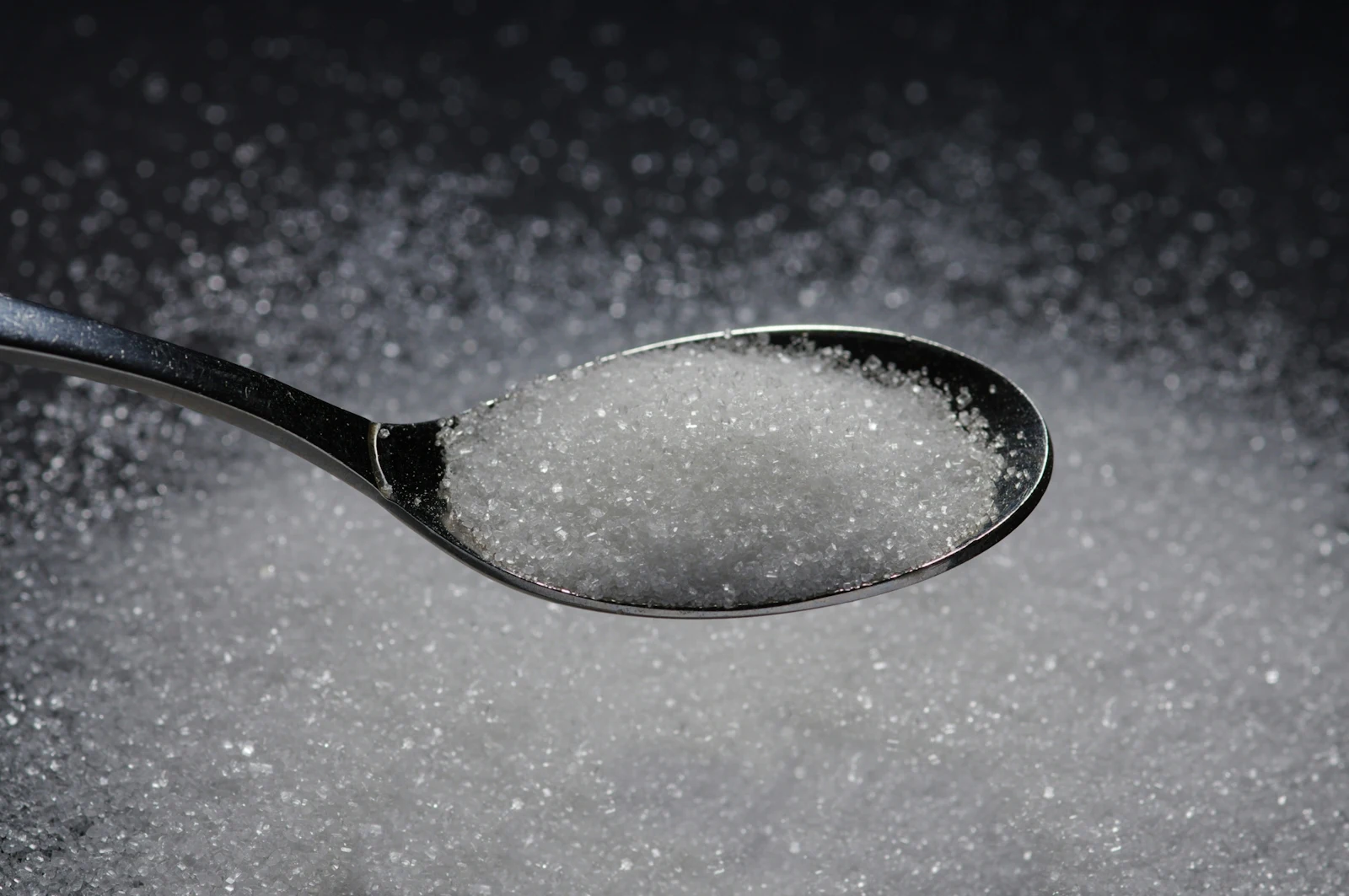 metal spoon with sugar in it