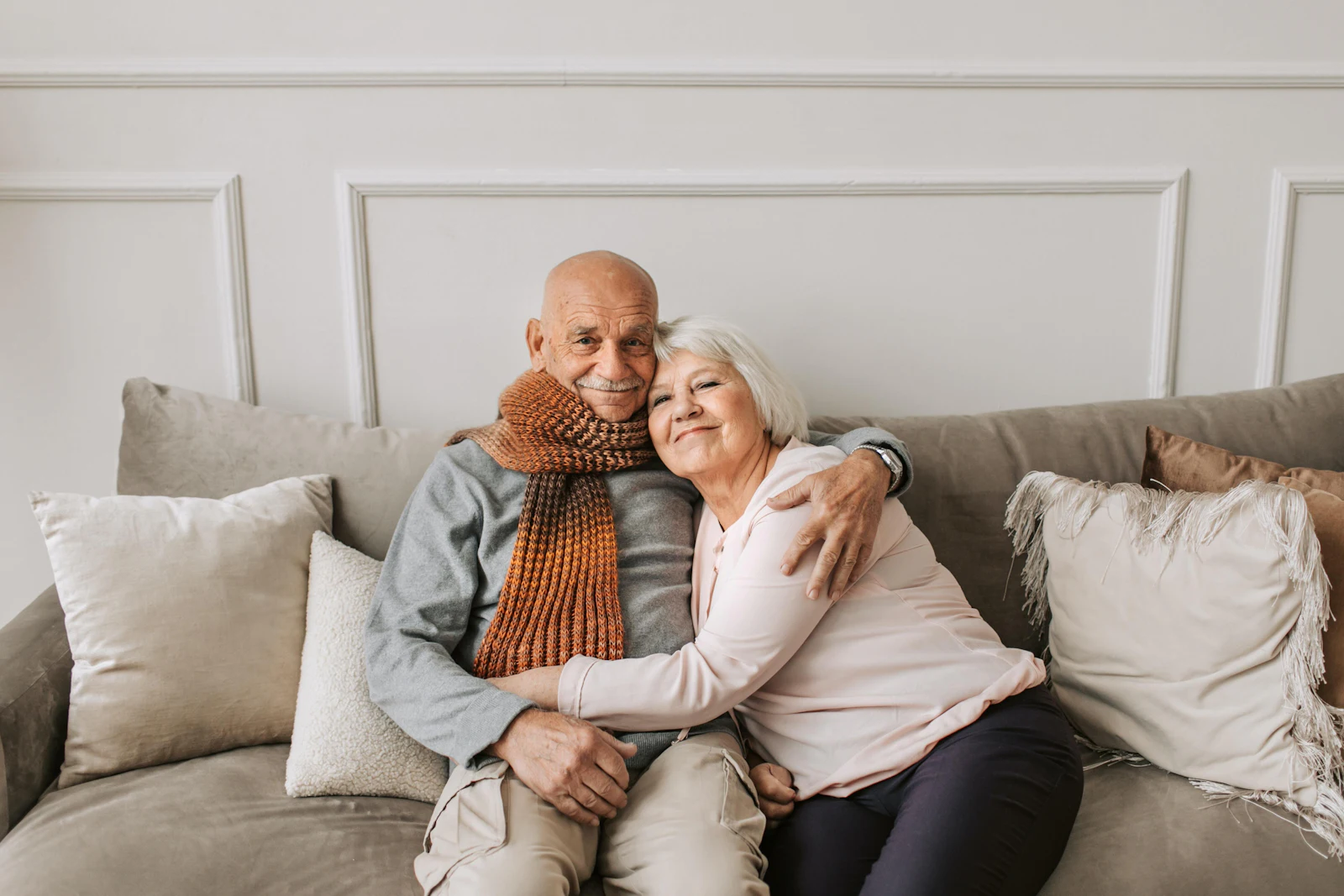 man and woman sitting on a couch hugging