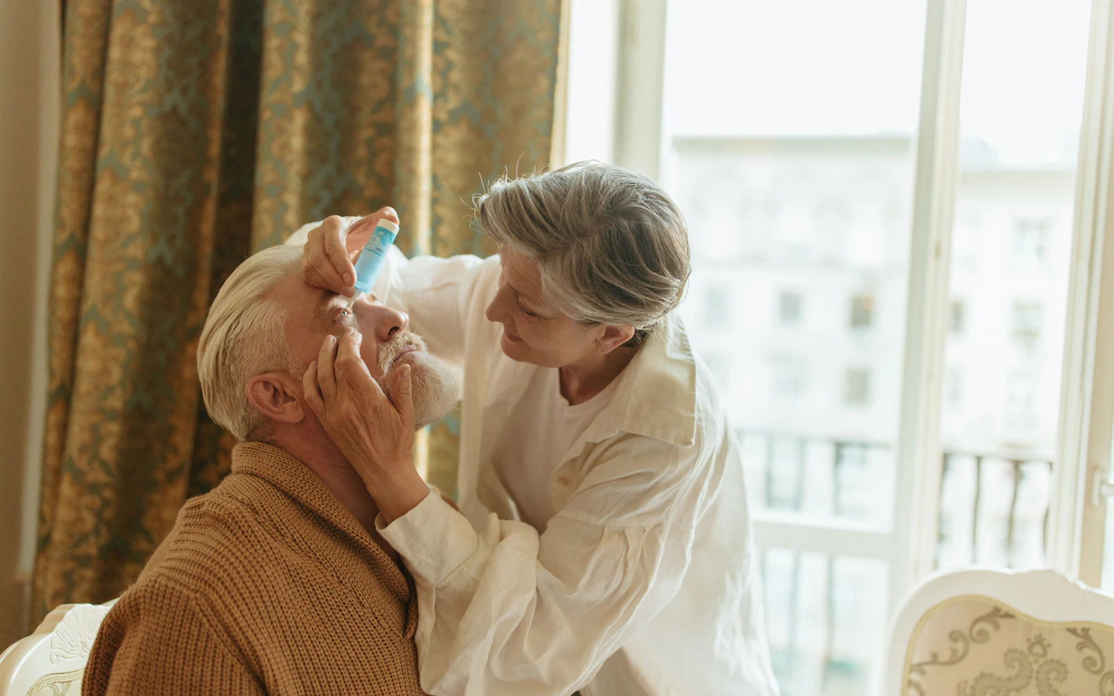 older couple eyedrops yellow curtains morning