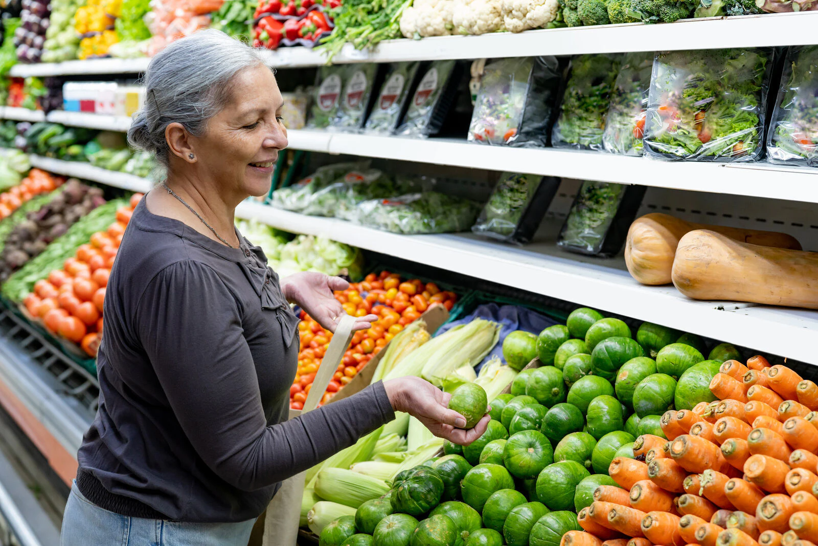 senior woman grocery shopping for vegetables
