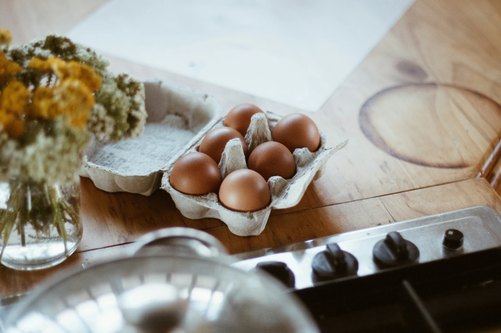 carton of eggs on counter by flowers